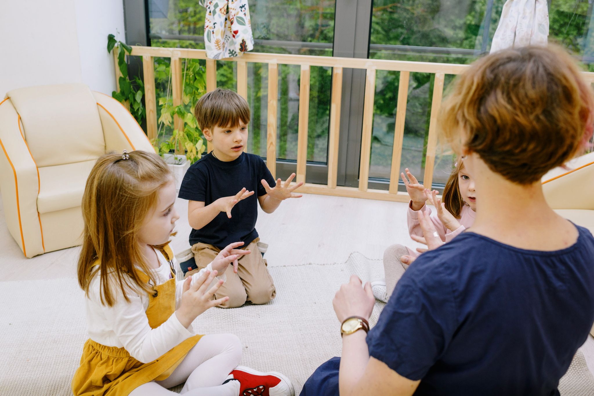 Teacher and children counting together in a bright indoor classroom setting.